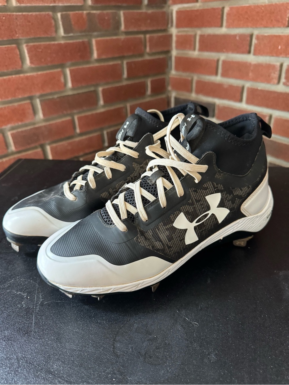 black and white Under Armour Yard Low baseball cleats with a subtle gray camo